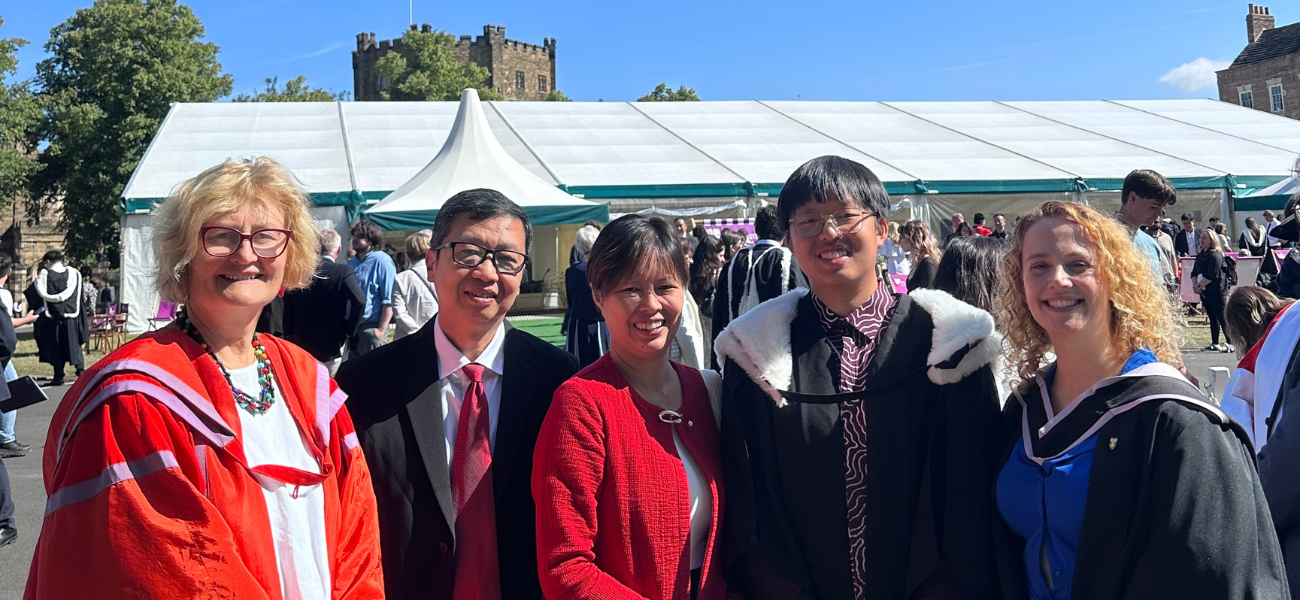 st chad's college principal stands with a graduate and his proud parents